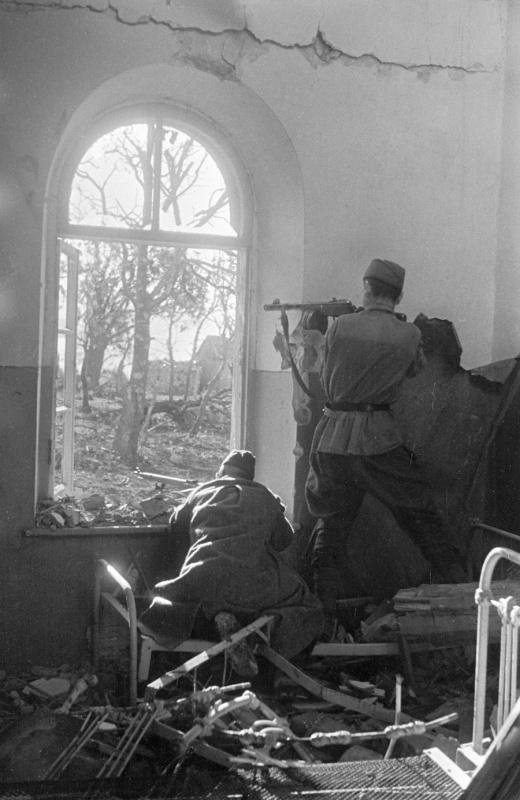 Советские бойцы ведут огонь из оконного проема в доме на окраине Новороссийска